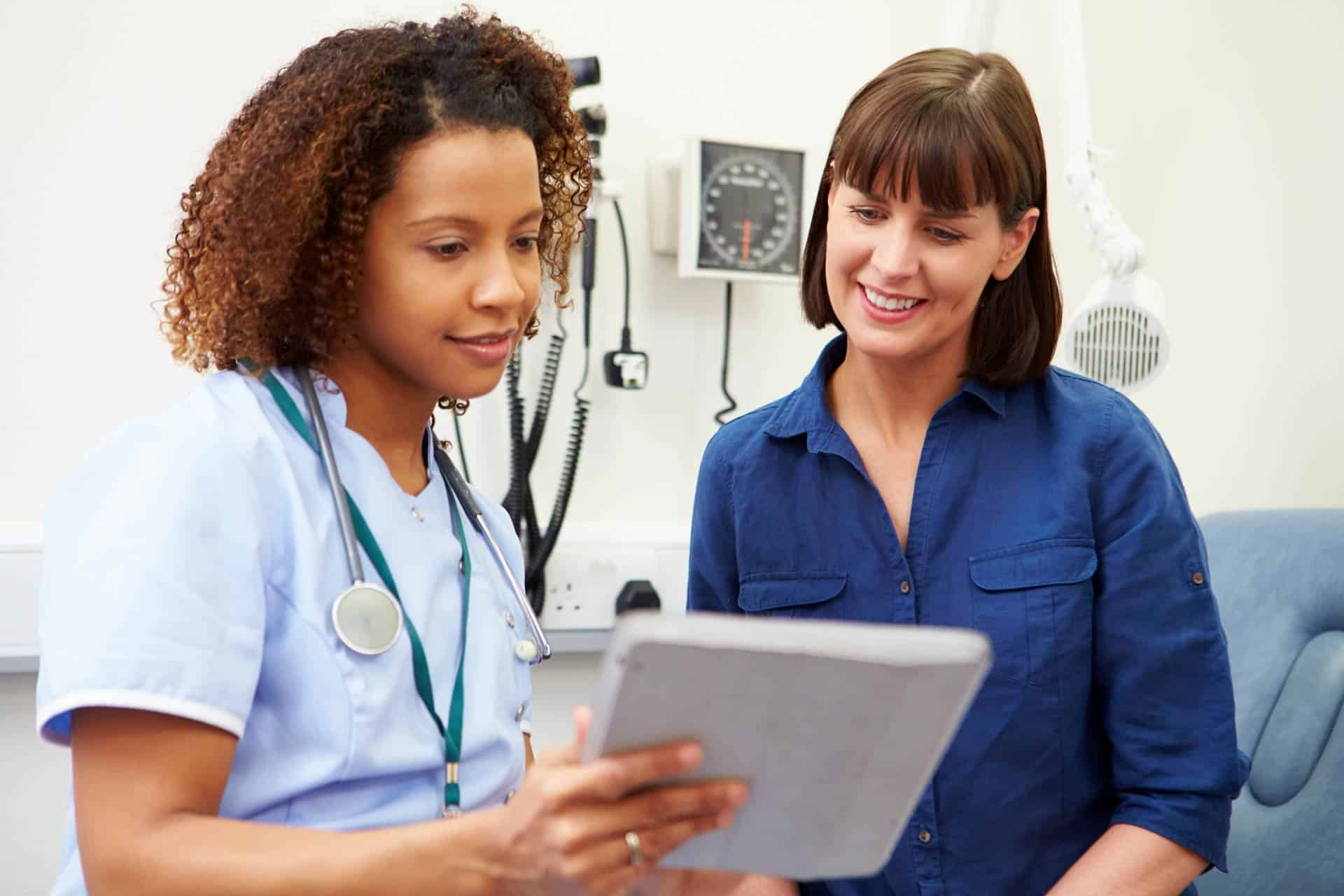 Nurse-discussing-chart-wtih-patient Nurse-discussing-chart-wtih-patient