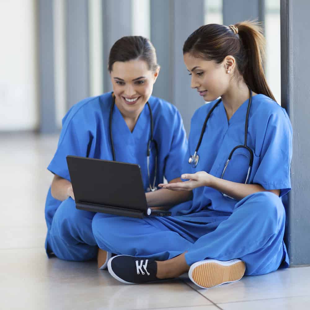 two nurses using laptop computer two nurses using laptop computer during break