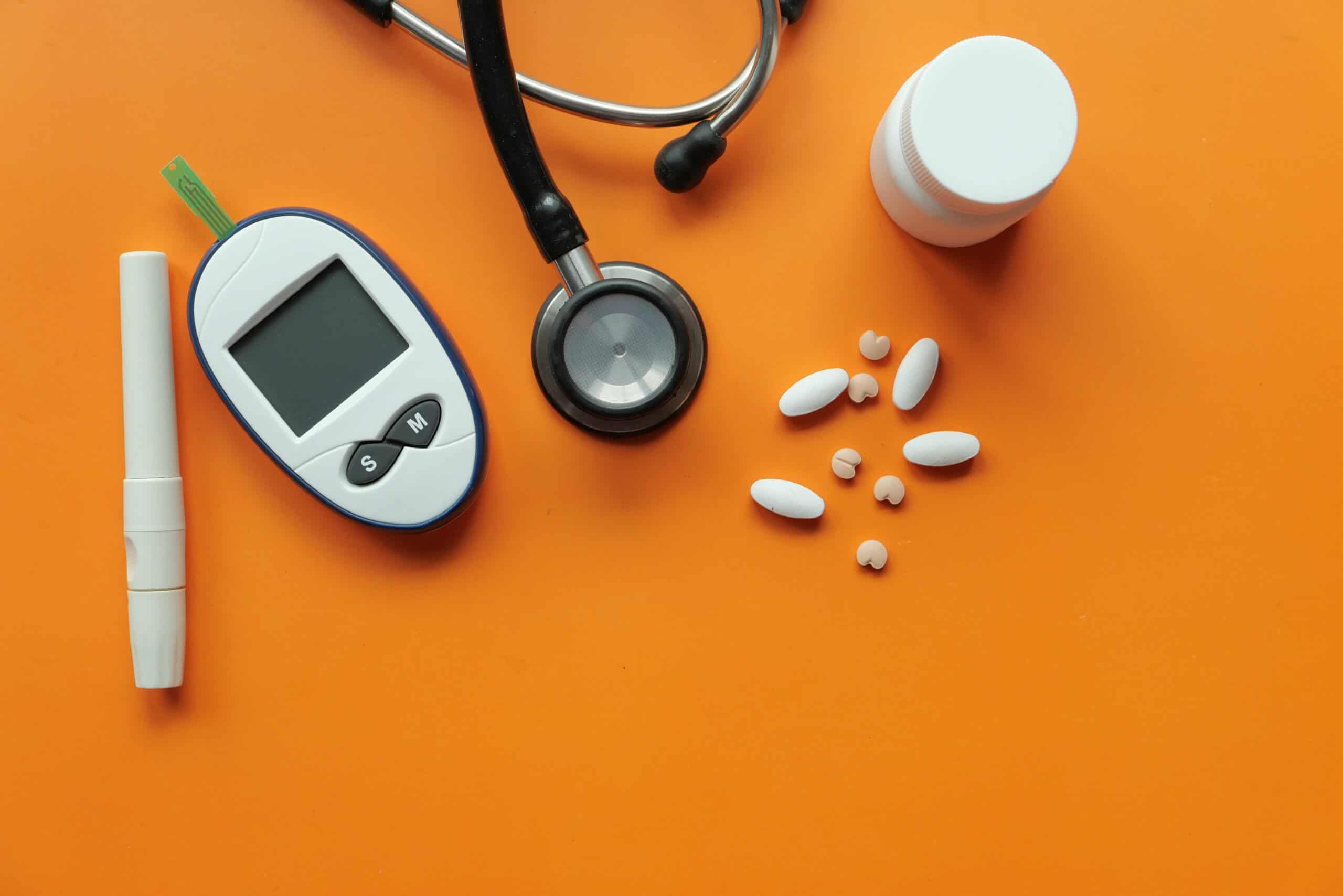 Glucometer, blood sugar measurement for diabetes, pills and stethoscope.