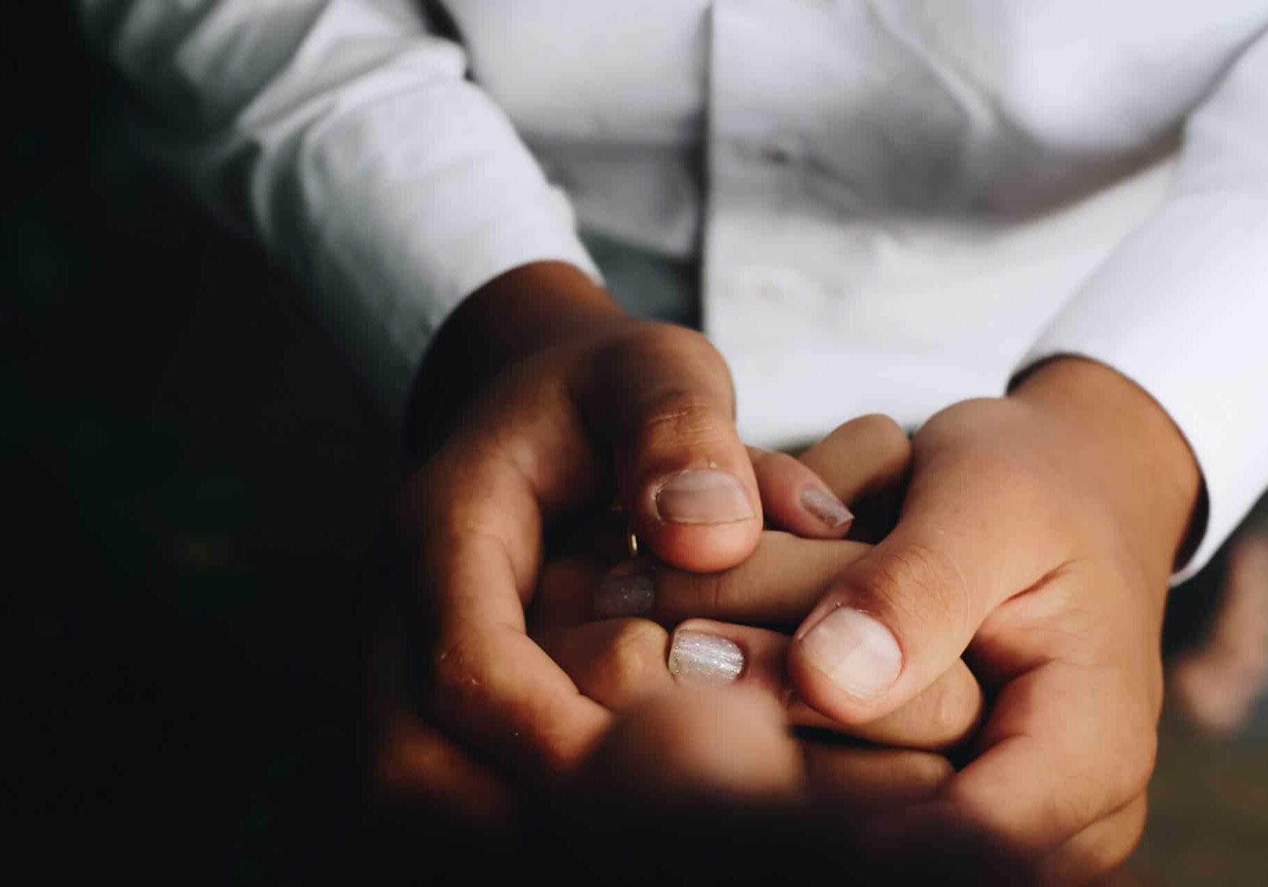 Healthcare provider holding a patients hand.